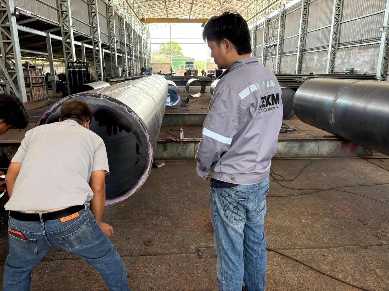 ผู้ตรวจพ่นน้ำยาตรวจแนวเชื่อมที่ฝาปิดทุ่น — ขั้นตอนการผลิตทุ่นเหล็ก T.K.M. Aquatic