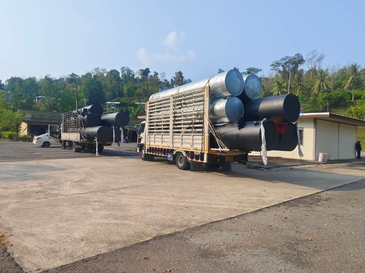 รถบรรทุกขนทุ่นเหล็กจอดรอที่ลานหน้าอาคาร — ขั้นตอนการผลิตทุ่นเหล็ก T.K.M. Aquatic