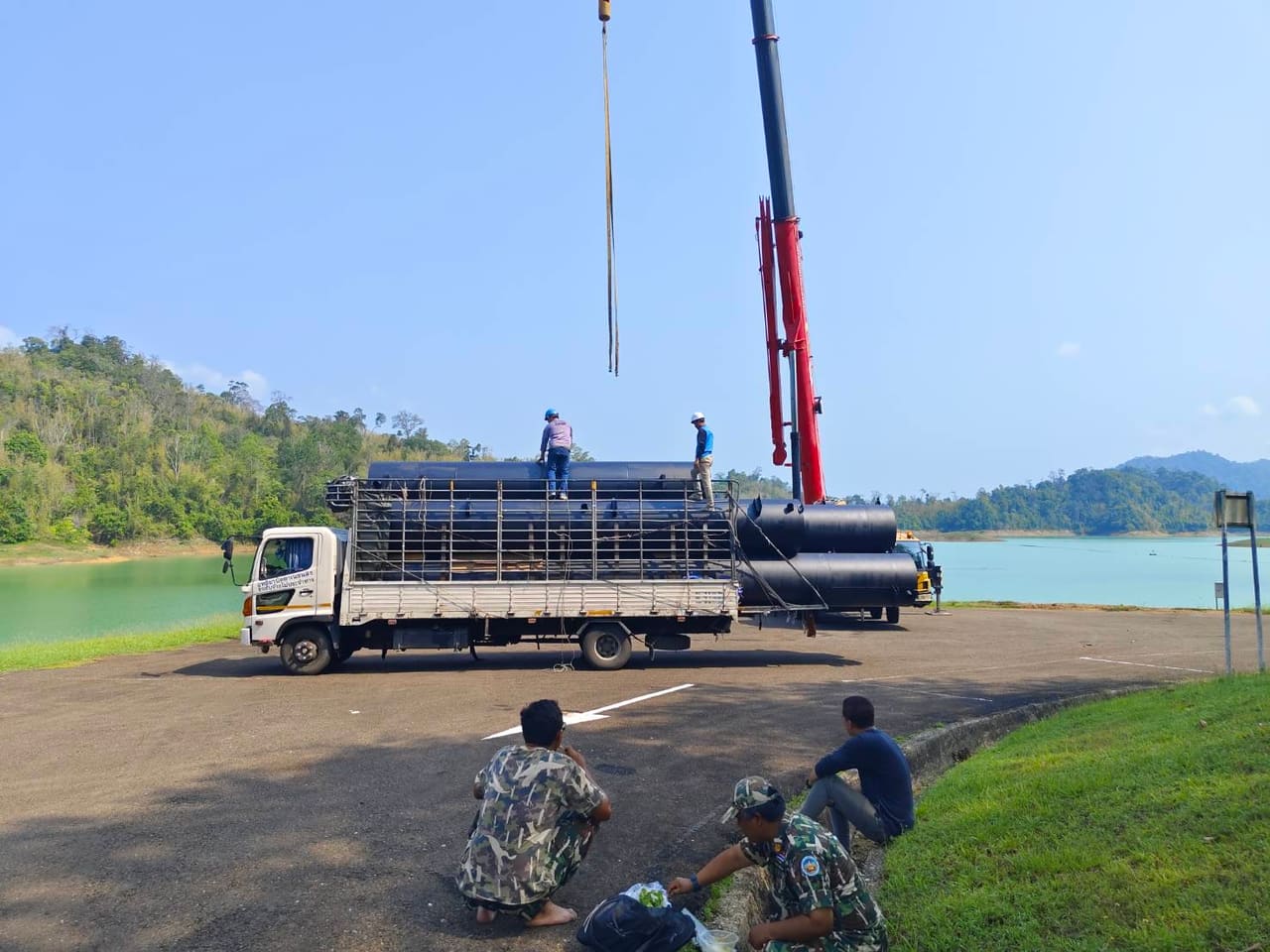 เครนยกทุ่นลงจากรถบรรทุกที่หน้างาน — ขั้นตอนการผลิตทุ่นเหล็ก T.K.M. Aquatic